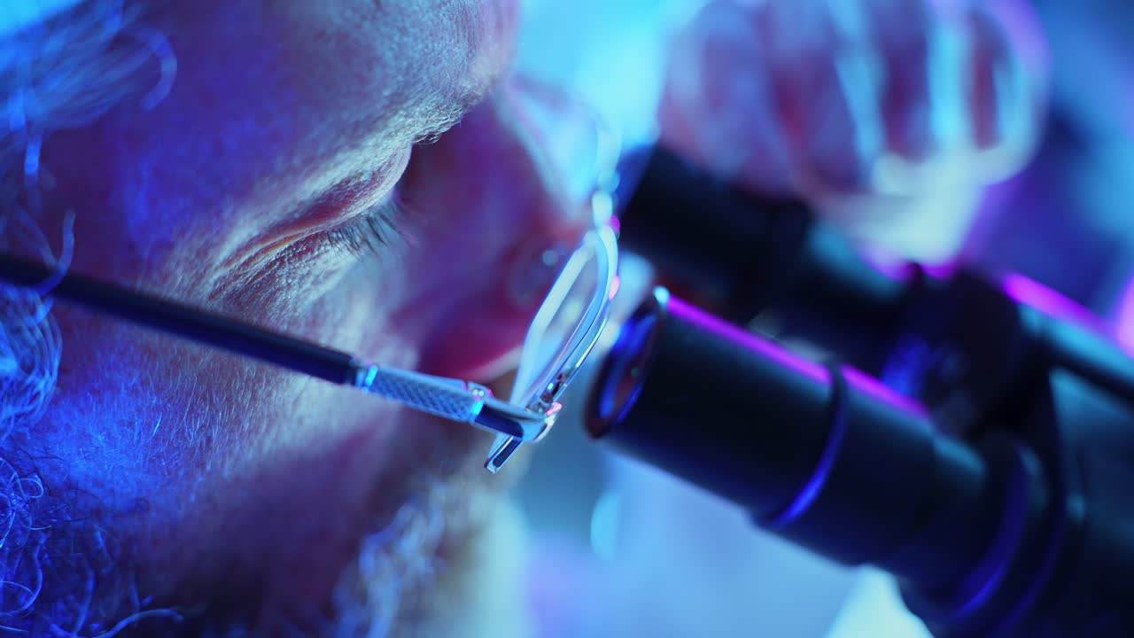 Scienziato che guarda al microscopio in un laboratorio moderno