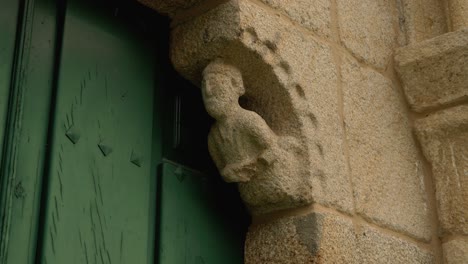 carved stone figure at the entrance of san paio de albán church in coles, galicia, spain