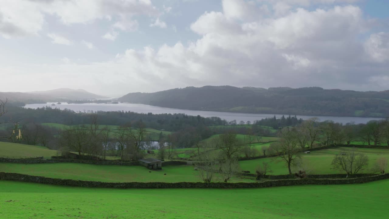 drone panorámica de la derecha a la izquierda del marco, mostrando la extensión de windermere, un pueblo de montaña junto al lago en cumbria, ubicado en el parque nacional del distrito de los lagos en gran bretaña
