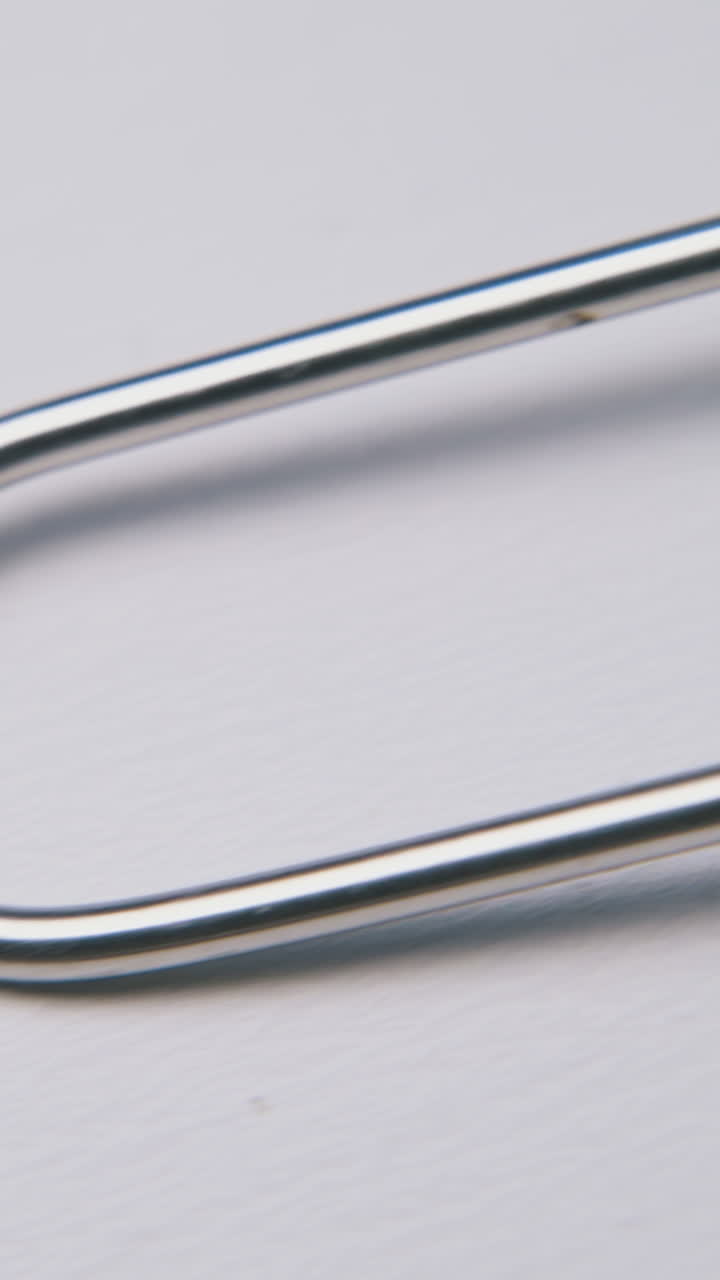 elegant stainless strainer with long thin handle lies on clean white background extreme close view