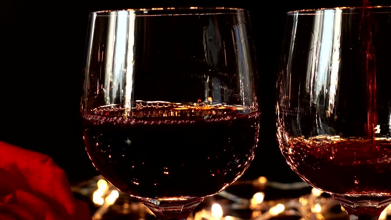 Weingläser und Rose vor dem Hintergrund heller Girlanden