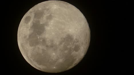 timelapse di una luna piena che si alza lentamente nel cielo notturno