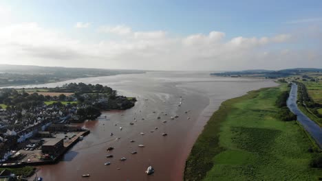 Szenische-Luftaufnahme-Von-Segelbooten,-Die-Im-Fluss-Exe-Neben-Grünen-Feldern-Und-Dem-Exeter-Kanal-Verankert-Sind