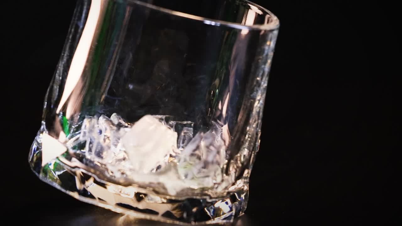 la mano deja caer cubos de hielo en un vaso