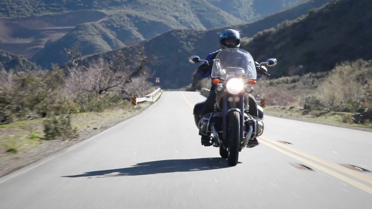 한 남자가 산길에서 오토바이를 타고 있다