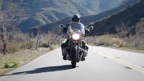 A-man-rides-a-motorcycle-on-a-mountain-road