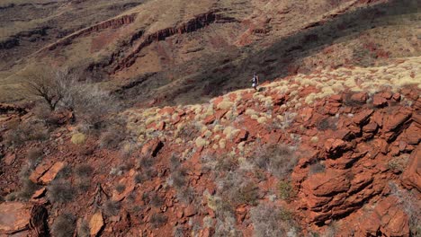 Drohnenaufnahme-Eines-Einsamen-Wanderers-Auf-Roten-Wüstenbergen-Im-Australischen-Nationalpark-Im-Sommer---Zeitlupe