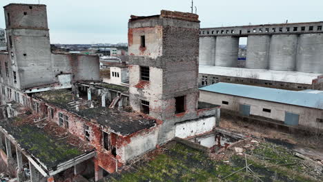 industrial area destroyed and devastated by time. old wrecked plant premises ready for demolition. excavators at the backdrop.