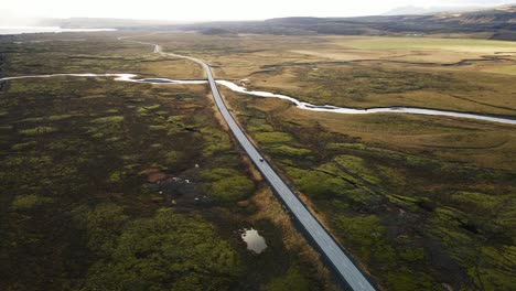 jib down of a car driving over a long road in a beautiful icelandic landscape