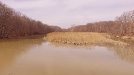 Aerial-footage-of-a-foot-bridge-crossing-an-icy-lake-during-the-winter-at-a-state-park