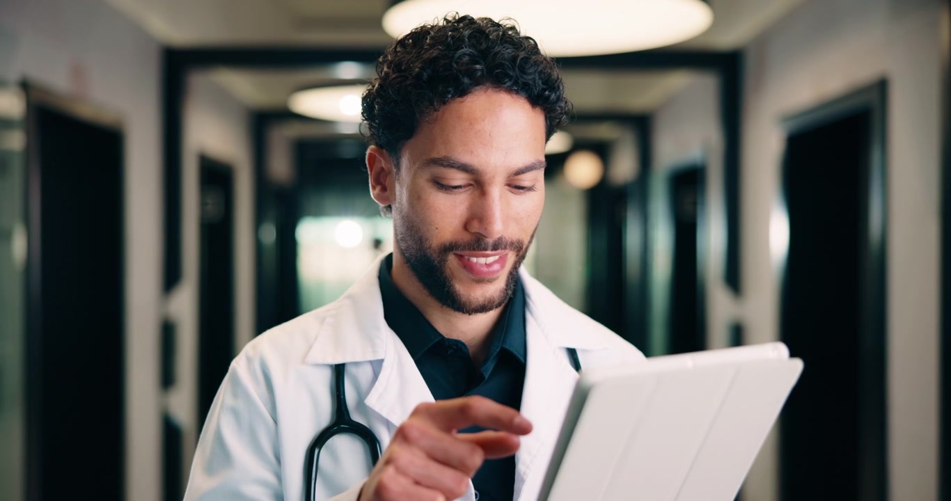 Medico uomo che utilizza un tablet digitale nel corridoio dell'ospedale