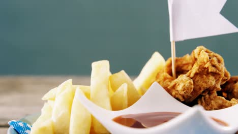 anillo de cebolla y papas fritas con ketchup dispuestas en un plato