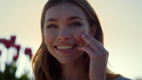 beautiful woman laughing in sun beams. happy blond girl touching face.