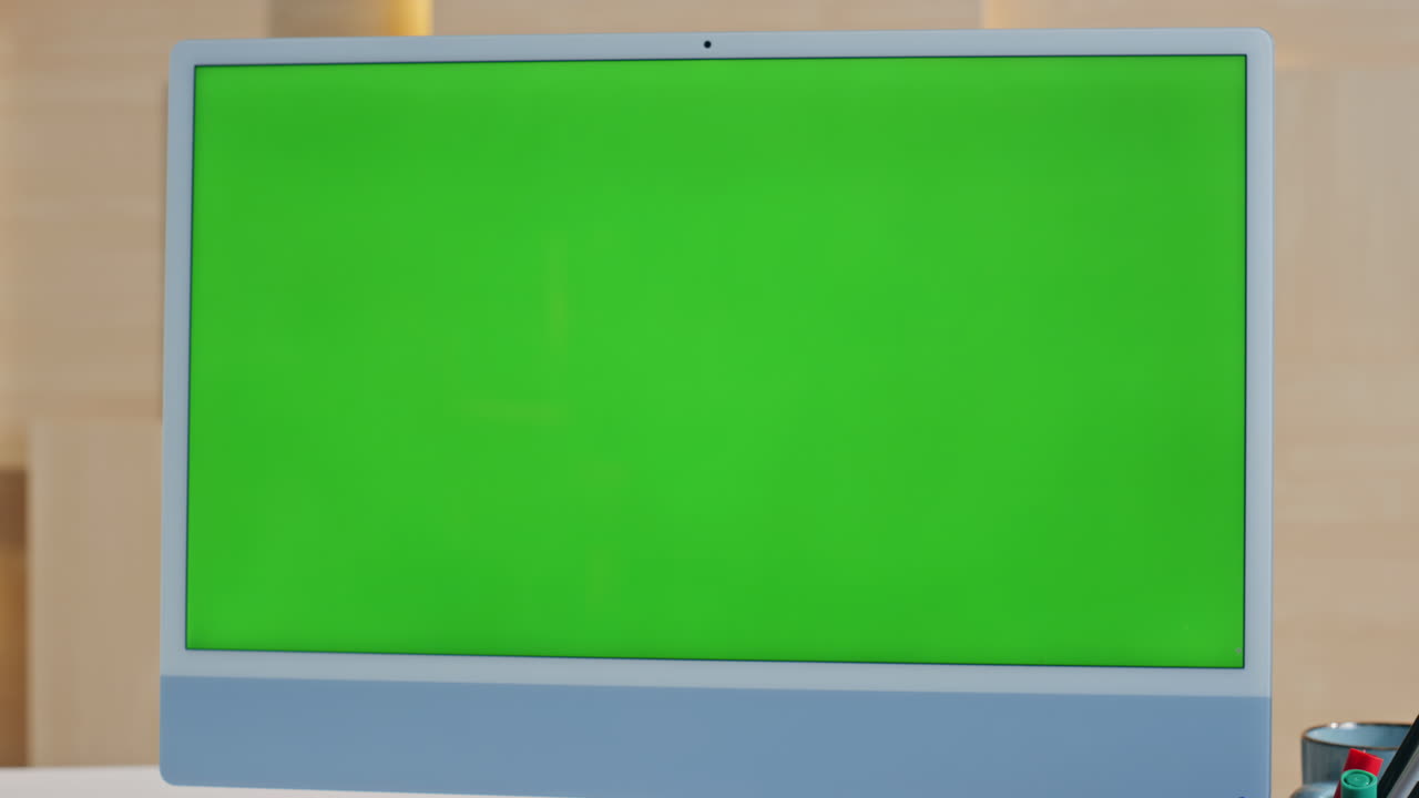 Green screen computer placed at empty workplace close up. Modern mockup monitor