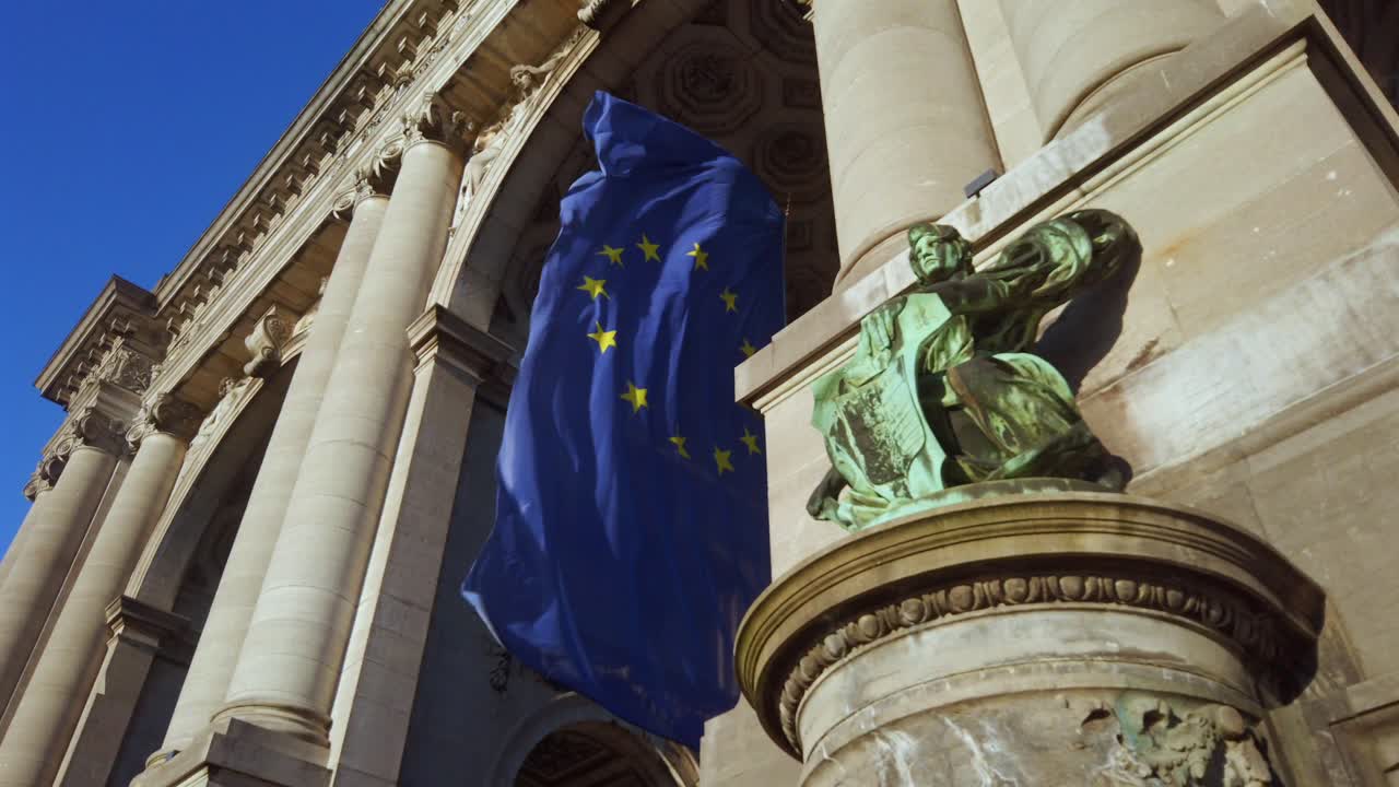 EU flag waving on neoclassical building in Brussels, Belgium