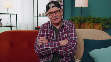 Portrait-of-happy-caucasian-senior-old-grandfather-in-casual-shirt-smiling-looking-at-camera-at-home