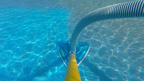 cleaning dirty pool with vacuum underwater on pole shot