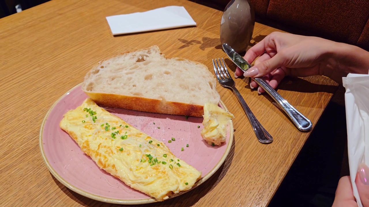 Breakfast setting, plated omelette sourdough slice, hand prepars to eat in cafe