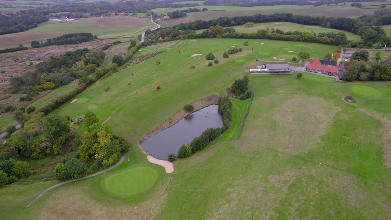 덴마크 의 푸른 숲 에 둘러싸인 조용 한 호수 를 특징 으로 하는 골프장 의 공중 사진