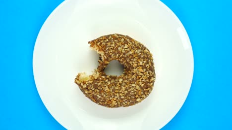 comiendo rosquillas de chocolate frescas sobre un fondo azul. donat girando. vista superior.