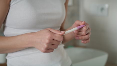 Detail-of-hands-of-unrecognizable-stressed-woman--waiting-for-pregnancy-test-results.