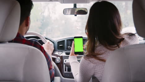 mujer pasajera que usa el gps en el teléfono inteligente durante el viaje en coche