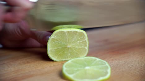 fresh lime fruit being sliced with sharp knife