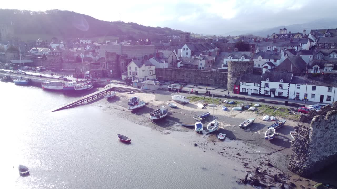 el idílico castillo de conwy y el puerto de la ciudad pesquera los barcos en la costanera aérea empujan tierra adentro lentamente