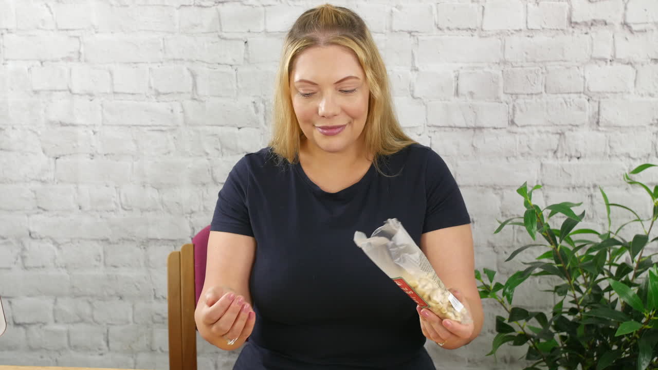 금발 여자 가 손 에 캐슈 견과류 를  ⁇ 고 있다