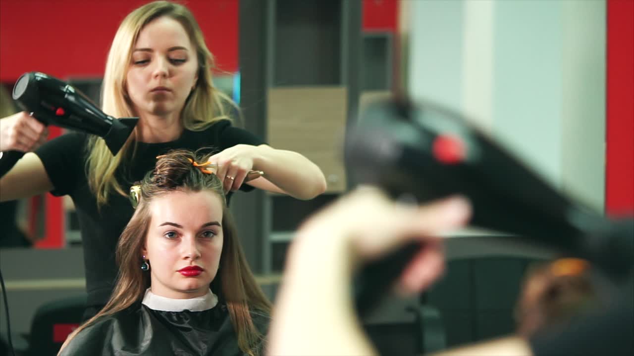 Woman getting her hair styled by a professional hairdresser in a salon