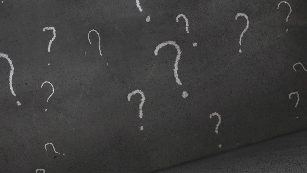 White question mark signs drawn on chalkboard