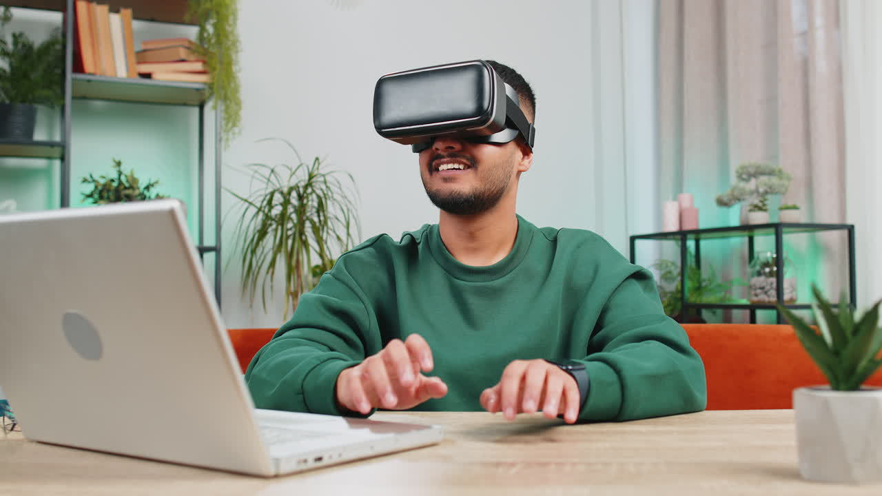 Indian man use virtual reality headset typing virtual keyboard play simulation 3d video game at home