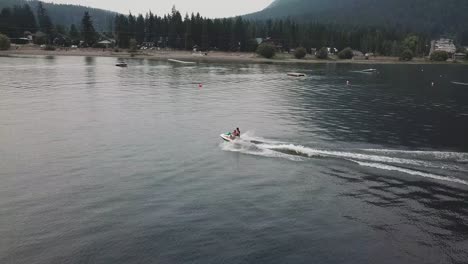 jet ski flying down the lake from a drone aerial view