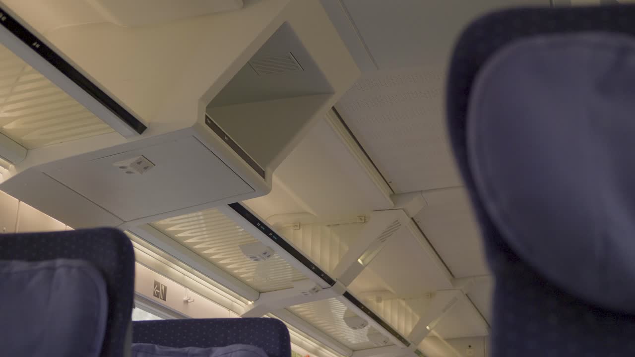 Modern overhead luggage rack in a German ICE train, showing calm travel atmosphere