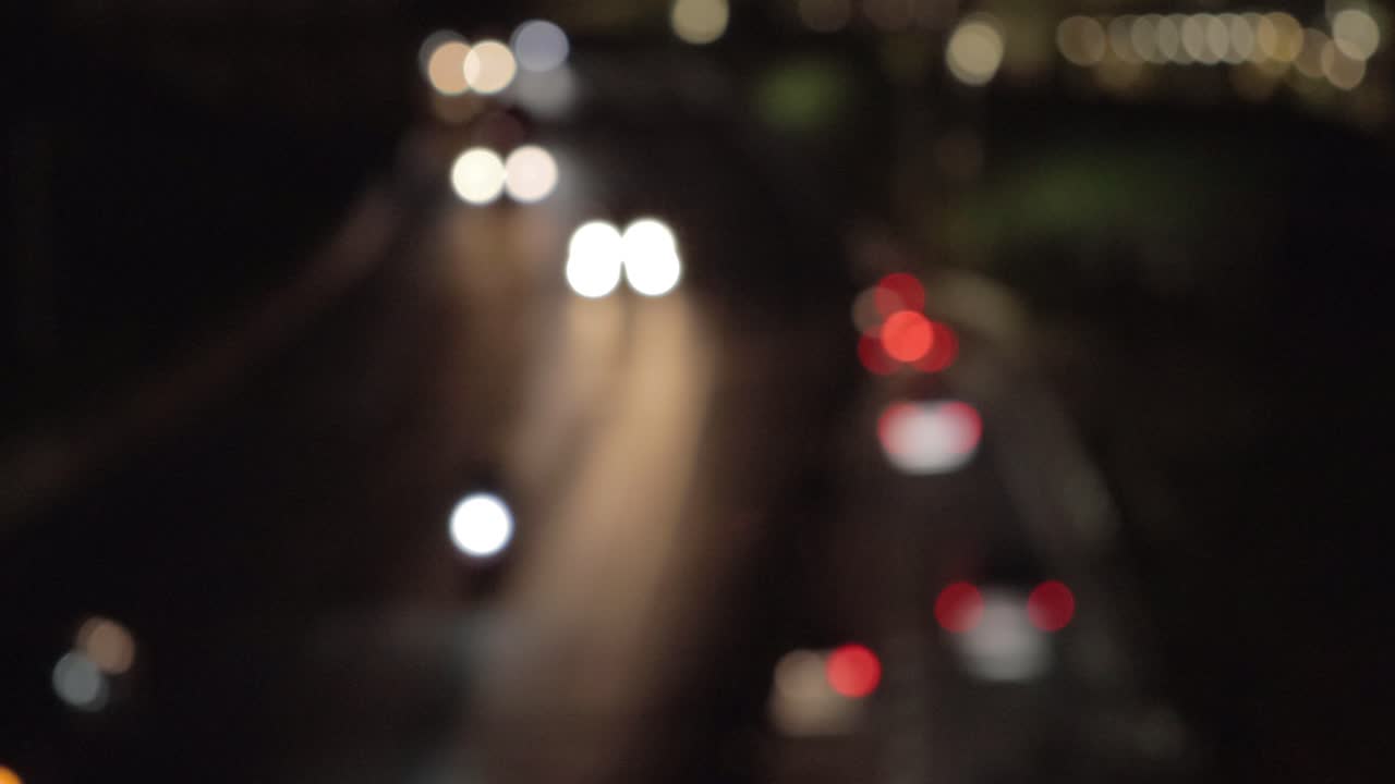 hermoso bokeh de los faros de los coches en una autopista de dos pisos en una gran ciudad por la noche