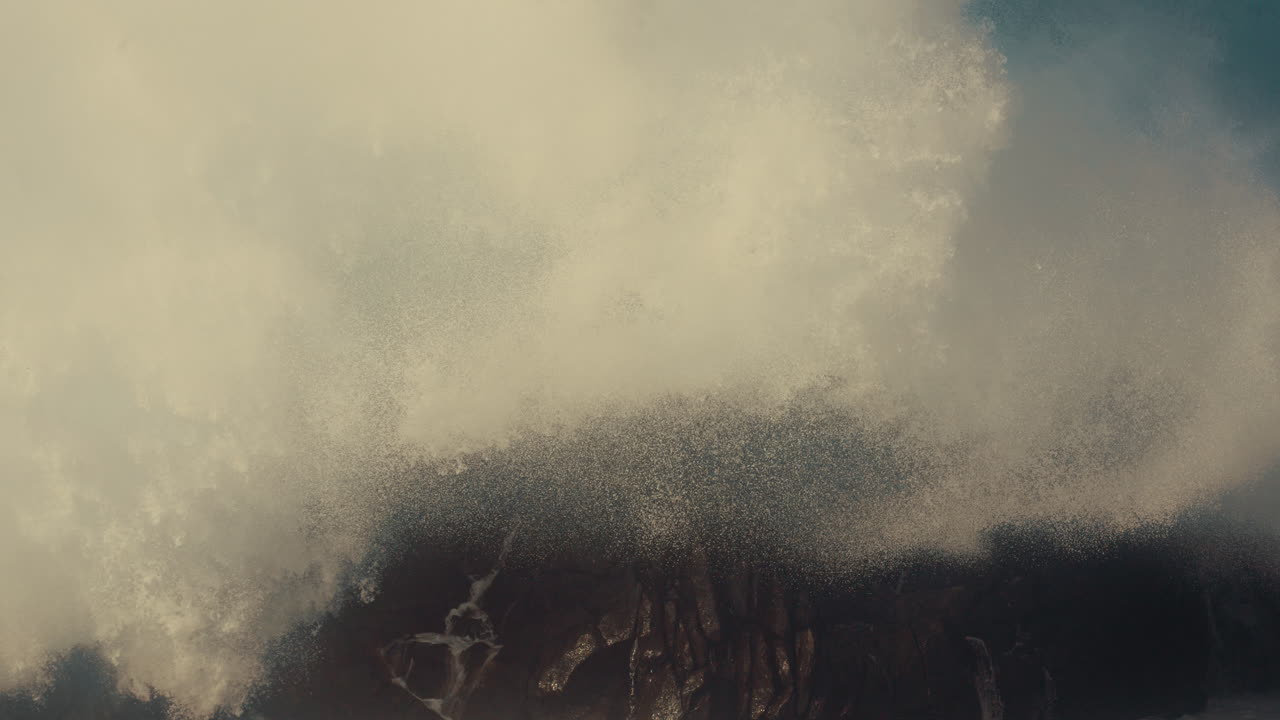 강한 파도가 바위 위에 부히고