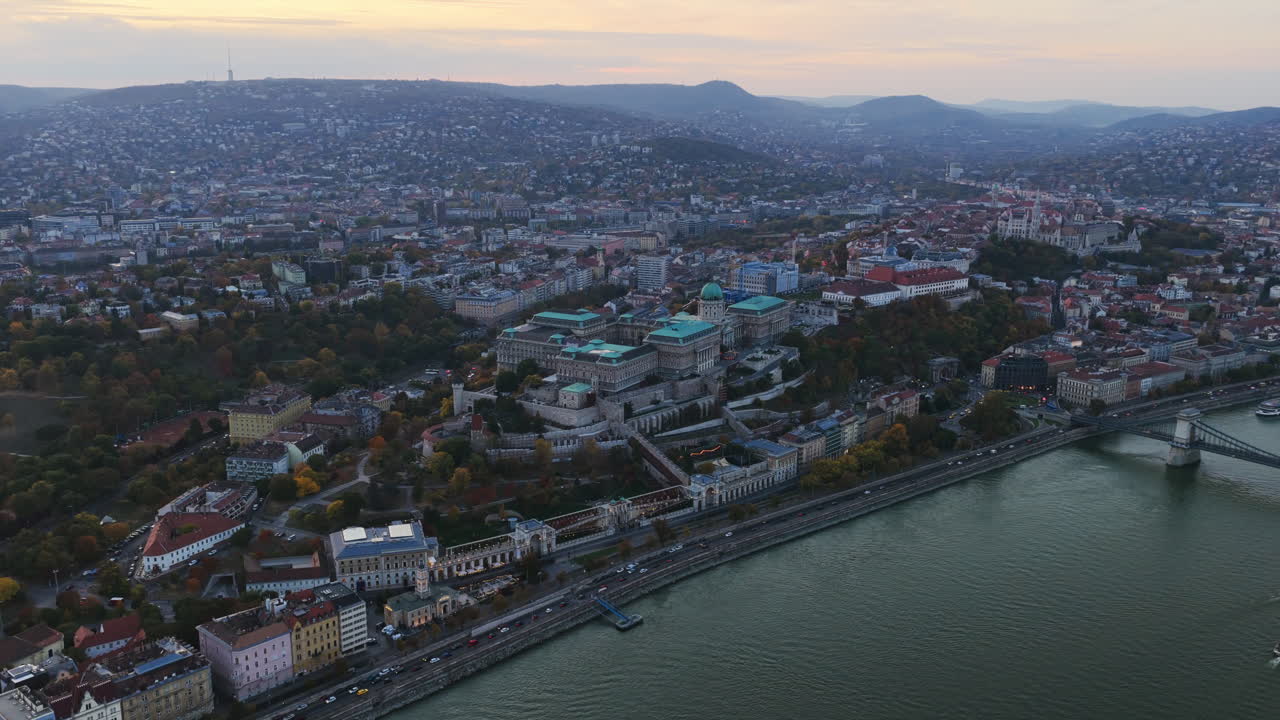 Aerial view of Buda Castle surrounded by the hills of Buda and the winding streets of Budapest at dusk