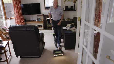 man cleaning carpet in living room