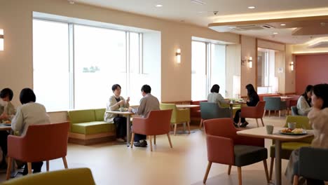 a cozy and modern cafeteria setting featuring diners enjoying their meals in a bright and inviting atmosphere with comfortable seating arrangements