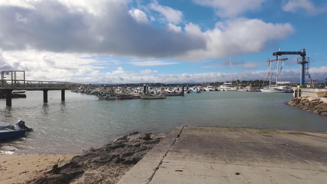 Boats moored at Alvor fishing harbour with cloudy sky and calm waters Portugal Algarve