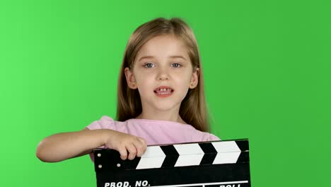 child holding clapperboard on green screen