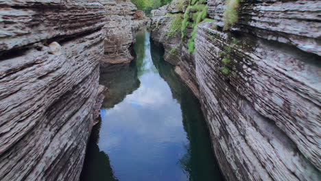 tranquil waters flow through the narrow cajones de chame canyon in panama, lush greenery speckling the cliffs