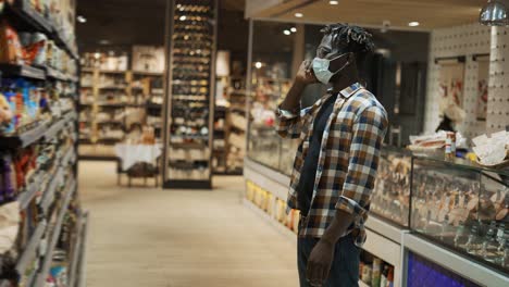 shopper talking by smartphone standing in front shelf