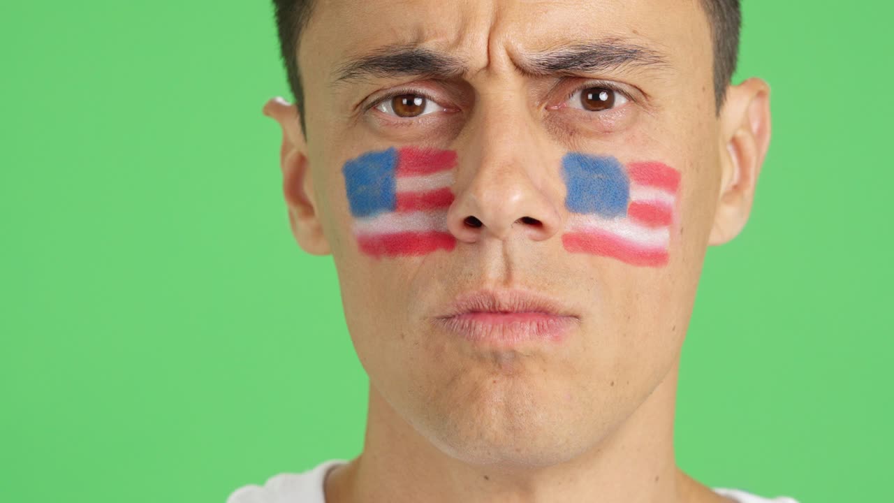 Serious man with a USA flag painted on the face