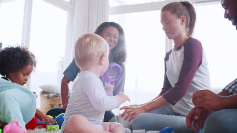 Freunde-Mit-Kleinkindern,-Die-Im-Wohnzimmer-Auf-Dem-Boden-Spielen