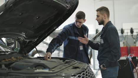 auto mechanic inspecting car engine in workshop