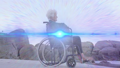 animación de la luz moviéndose sobre una mujer caucásica mayor sonriente en silla de ruedas en la playa mirando al mar