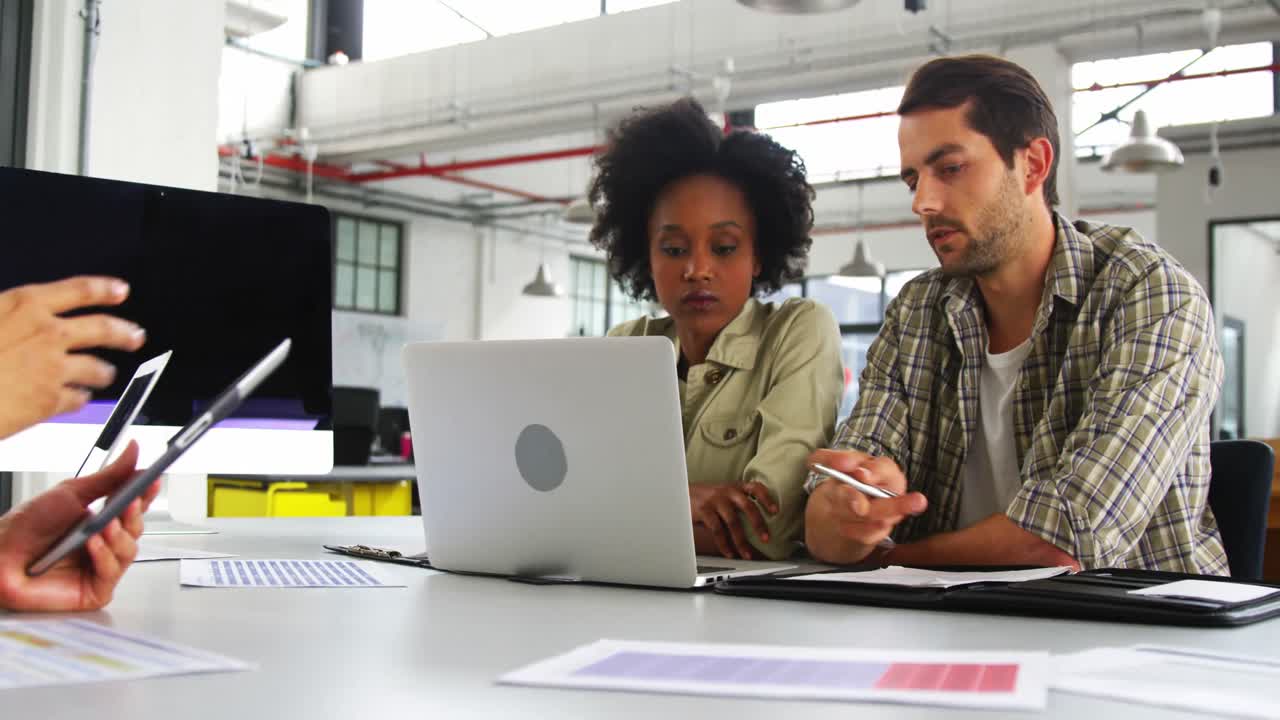 Business executives discussing over laptop
