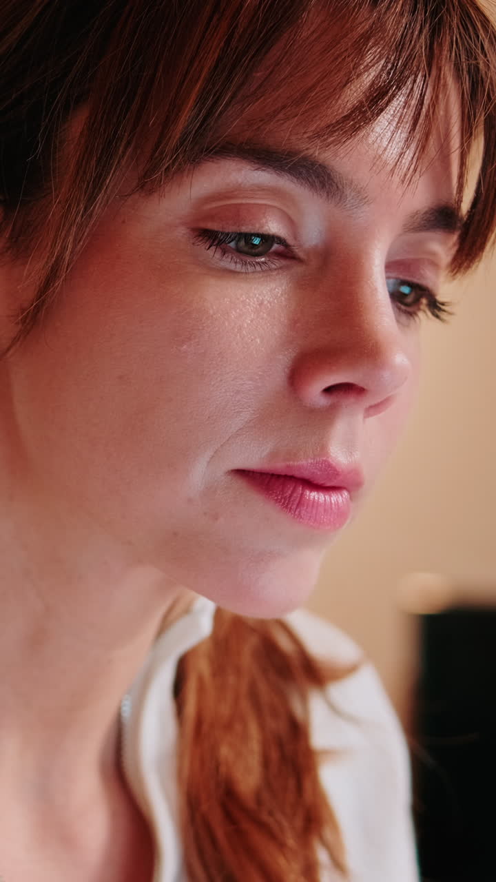 Primo piano di una giovane donna pensierosa che guarda in basso
