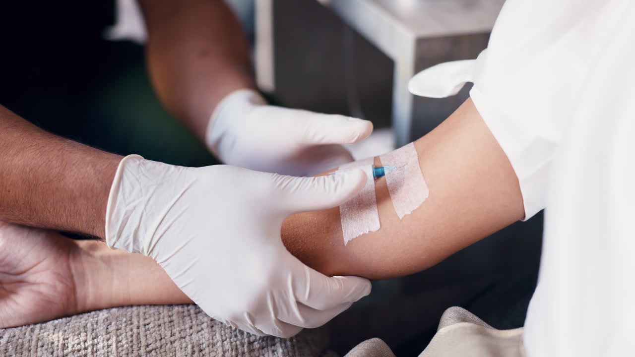 Close Up of Medical Professional Administering IV Drip to Patient's Arm